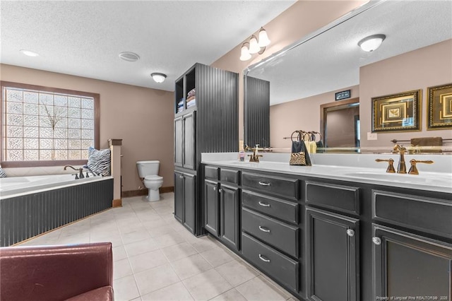 bathroom featuring double vanity, tile patterned floors, a textured ceiling, toilet, and a sink