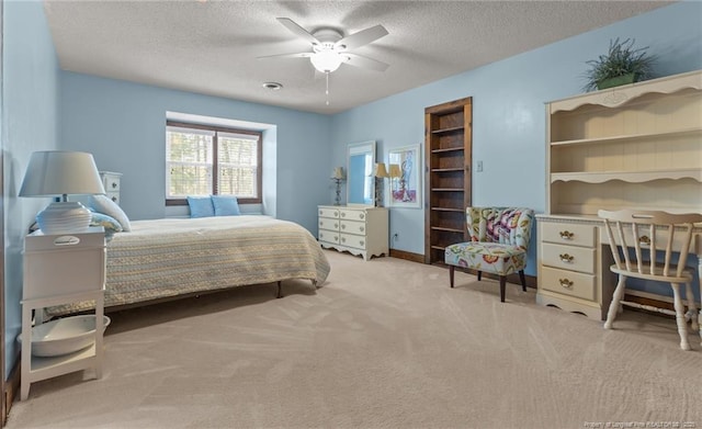 bedroom with light carpet, a textured ceiling, and ceiling fan