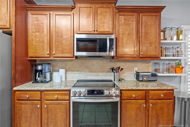 33 Woodbury Ln, Sanford, NC 27332 - kitchen with light stone countertops, stainless steel appliances, brown cabinetry, and backsplash
