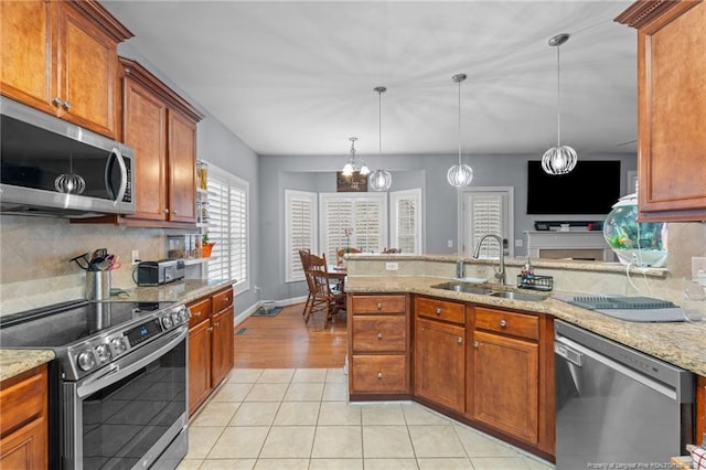 33 Woodbury Ln, Sanford, NC 27332 - kitchen featuring brown cabinetry, a sink, light tile patterned flooring, tasteful backsplash, and appliances with stainless steel finishes