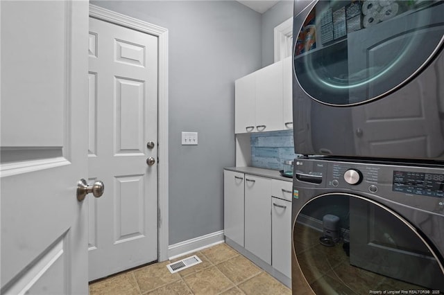 33 Woodbury Ln, Sanford, NC 27332 - washroom featuring stacked washer and dryer, baseboards, visible vents, and cabinet space
