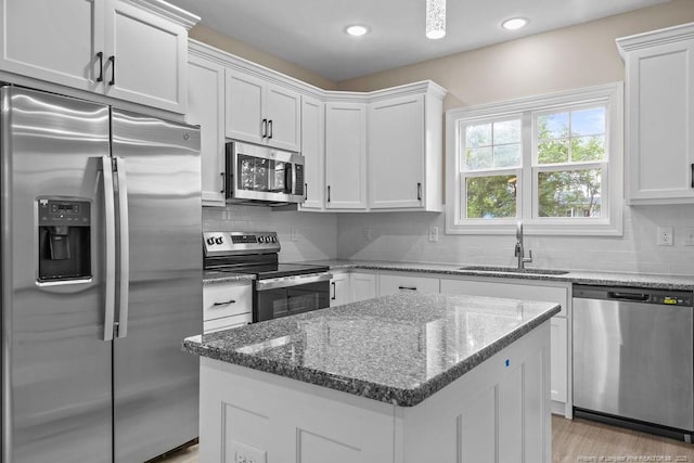 432 Timberline Dr, Fayetteville, NC 28311 - kitchen with stainless steel appliances, a sink, a kitchen island, white cabinets, and decorative backsplash