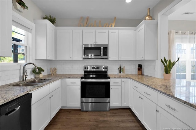 508 Rempstone Ln, Fayetteville, NC 28311 - kitchen featuring a sink, decorative backsplash, appliances with stainless steel finishes, white cabinetry, and dark wood-style flooring