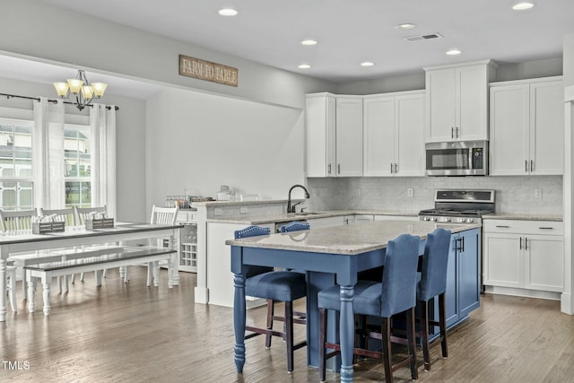 2801 Landon Ridge Dr, New Hill, NC 27562 - kitchen with white cabinets, wood finished floors, and stainless steel appliances