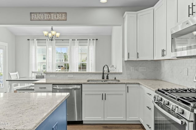 2801 Landon Ridge Dr, New Hill, NC 27562 - kitchen featuring an inviting chandelier, a sink, decorative backsplash, white cabinets, and appliances with stainless steel finishes