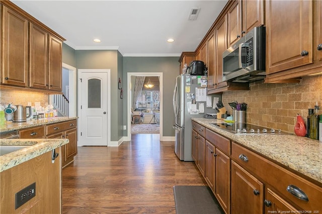 kitchen with stainless steel appliances, light stone countertops, decorative backsplash, crown molding, and brown cabinetry