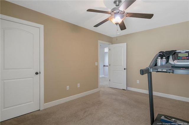 exercise area with carpet flooring, a ceiling fan, and baseboards