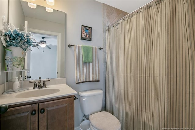 bathroom with ceiling fan, vanity, toilet, and a shower with curtain