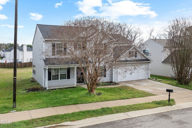 traditional-style house featuring covered porch, a front yard, driveway, and fence