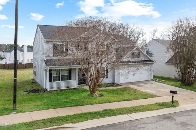 traditional-style home with driveway, covered porch, fence, and a front yard