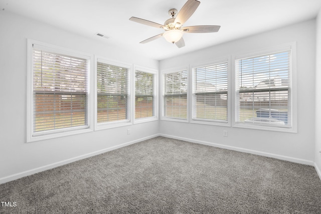 unfurnished sunroom featuring carpet, baseboards, and visible vents
