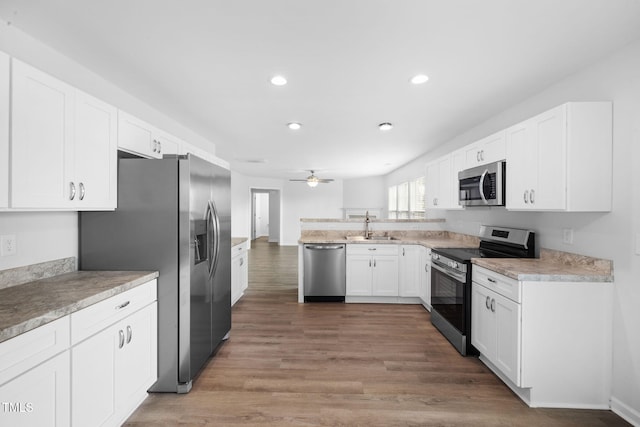 kitchen featuring white cabinetry, a sink, stainless steel appliances, and a ceiling fan
