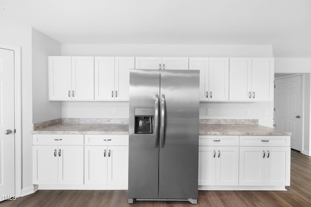 kitchen featuring light countertops, white cabinets, stainless steel fridge with ice dispenser, and dark wood finished floors