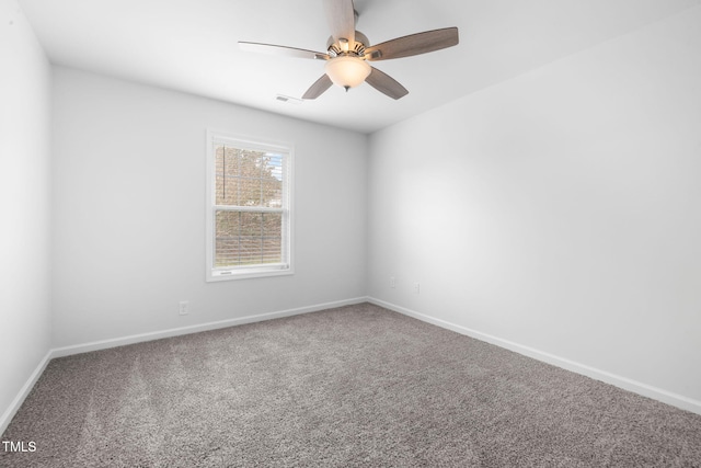 empty room with carpet floors, baseboards, visible vents, and ceiling fan