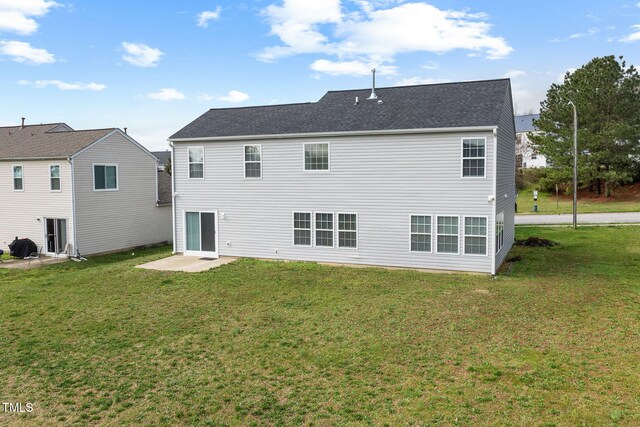 rear view of property with a lawn and a patio