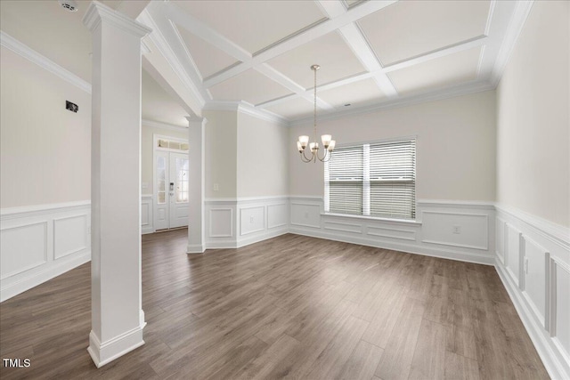 unfurnished dining area with a notable chandelier, coffered ceiling, a healthy amount of sunlight, and decorative columns