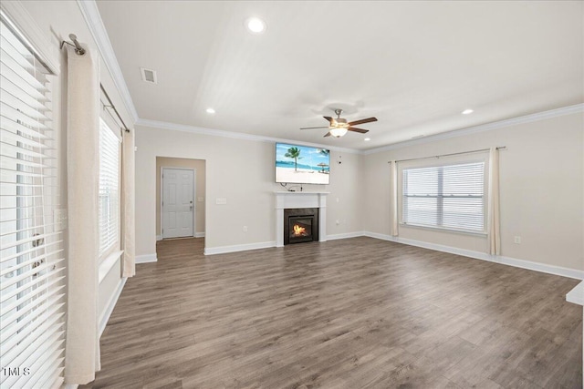 unfurnished living room featuring wood finished floors, plenty of natural light, a ceiling fan, and visible vents