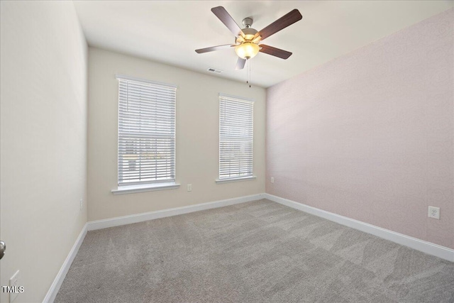 spare room with visible vents, baseboards, carpet, and ceiling fan