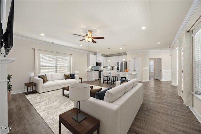 living area with ceiling fan, crown molding, wood finished floors, and recessed lighting