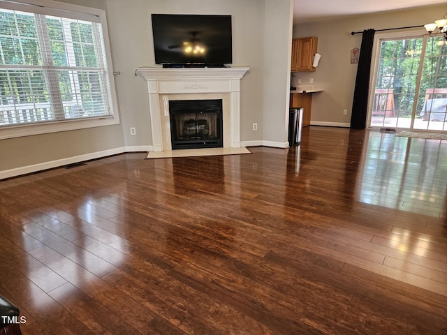 4116 Tall Pine Dr, Franklinton, NC 27525 - unfurnished living room with dark wood-style flooring, a fireplace with flush hearth, and baseboards