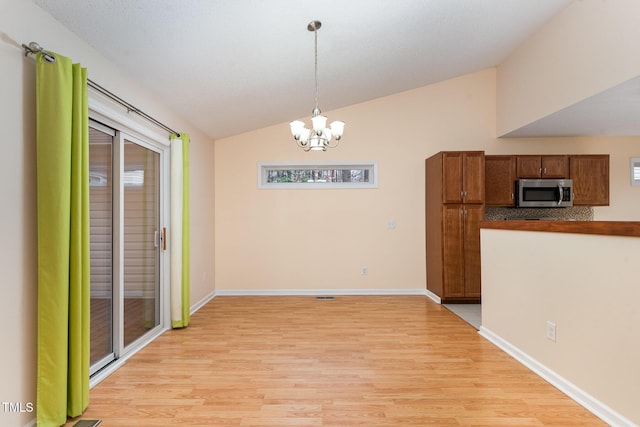 1603 Stonegate S, Sanford, NC 27332 - unfurnished dining area with an inviting chandelier, light wood-style flooring, baseboards, and lofted ceiling