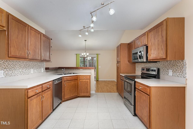 1603 Stonegate S, Sanford, NC 27332 - kitchen featuring vaulted ceiling, a sink, a peninsula, brown cabinetry, and stainless steel appliances
