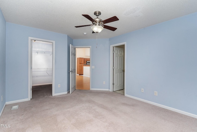 1603 Stonegate S, Sanford, NC 27332 - unfurnished bedroom featuring a closet, light carpet, a spacious closet, a textured ceiling, and baseboards