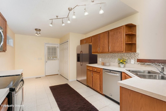 1603 Stonegate S, Sanford, NC 27332 - kitchen featuring backsplash, a sink, appliances with stainless steel finishes, and brown cabinets