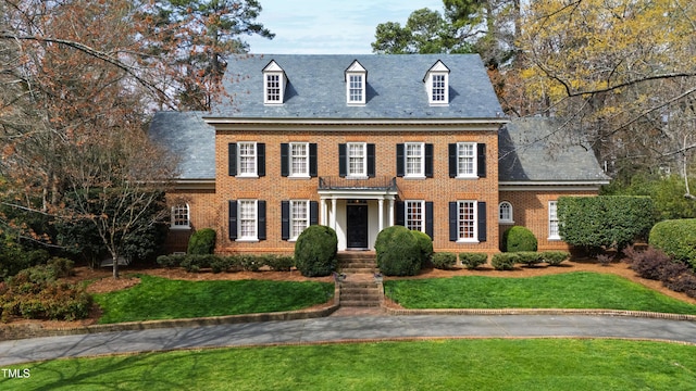 colonial house with brick siding and a front yard
