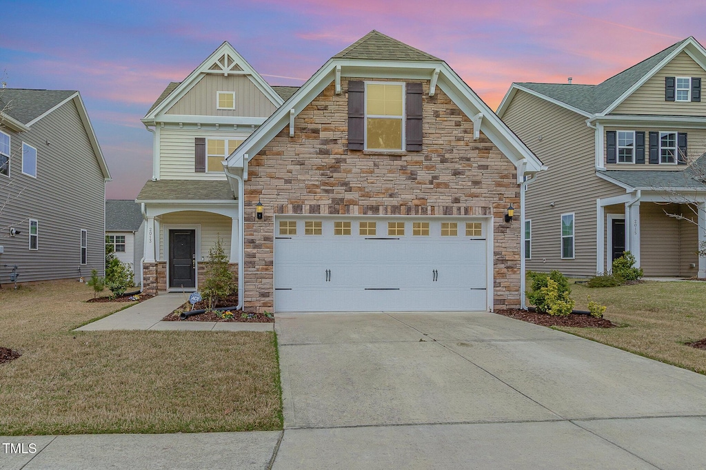 2013 Magnolia Tree Ln, Durham, NC 27703 - craftsman-style home with a front yard, stone siding, a garage, board and batten siding, and concrete driveway
