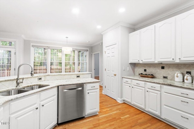 kitchen featuring dishwasher, a sink, ornamental molding, decorative backsplash, and healthy amount of natural light