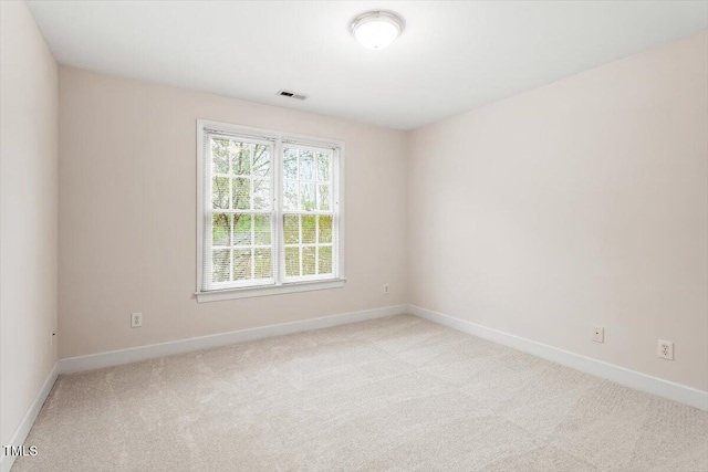 unfurnished room with light carpet and baseboards