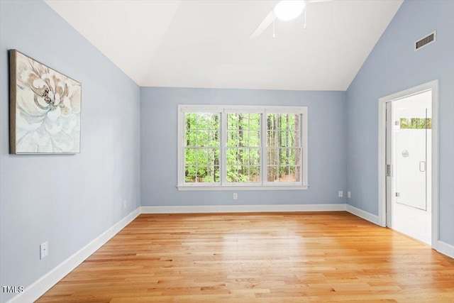 empty room with lofted ceiling, light wood finished floors, a ceiling fan, and baseboards