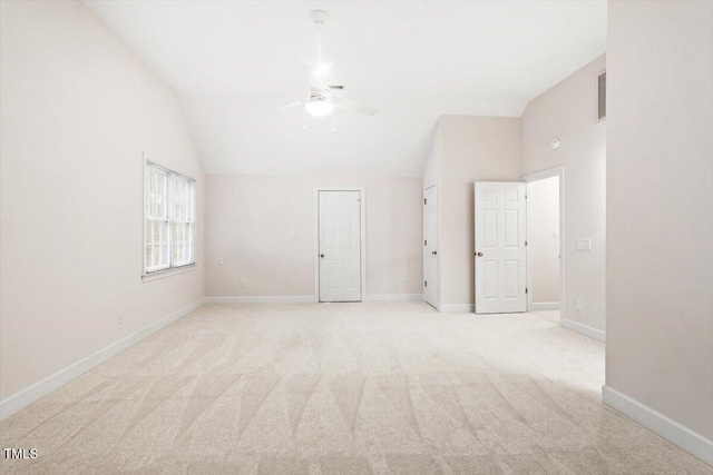 unfurnished room with lofted ceiling, ceiling fan, light colored carpet, and baseboards