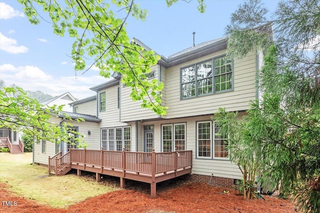 rear view of property featuring a wooden deck and crawl space
