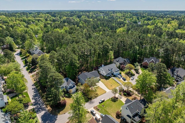 aerial overview of property's location with a forest and nearby suburban area