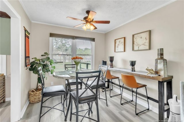 1002 Hicks Ave, Fayetteville, NC 28304 - dining space with ornamental molding, light wood finished floors, and a textured ceiling