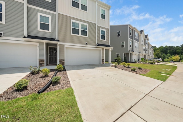 3025 Castle Loch Ln, Durham, NC 27703 - view of front facade with an attached garage, concrete driveway, stone siding, and board and batten siding