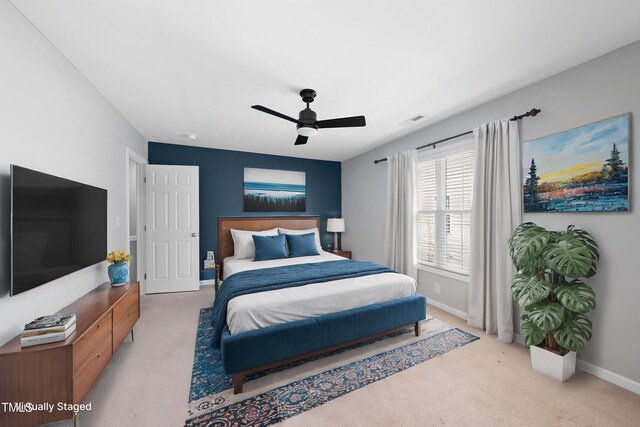 carpeted bedroom featuring baseboards, visible vents, and a ceiling fan