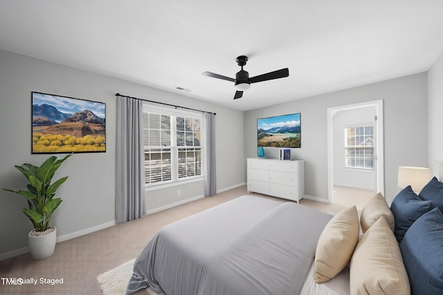 bedroom with multiple windows, visible vents, baseboards, and light carpet