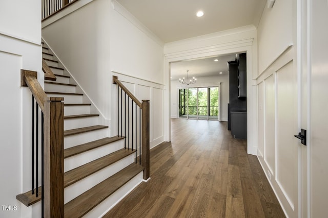 8620 Dukes Lake Rd, Zebulon, NC 27597 - stairs with a chandelier, wood finished floors, a decorative wall, crown molding, and recessed lighting