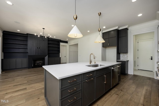 8620 Dukes Lake Rd, Zebulon, NC 27597 - kitchen featuring dishwasher, light wood-style flooring, a kitchen island with sink, a chandelier, and light countertops