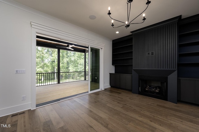 8620 Dukes Lake Rd, Zebulon, NC 27597 - unfurnished living room with wood finished floors, a chandelier, and crown molding