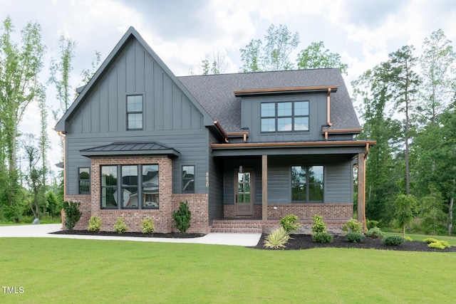 8620 Dukes Lake Rd, Zebulon, NC 27597 - view of front of home featuring board and batten siding, brick siding, a front yard, and a porch