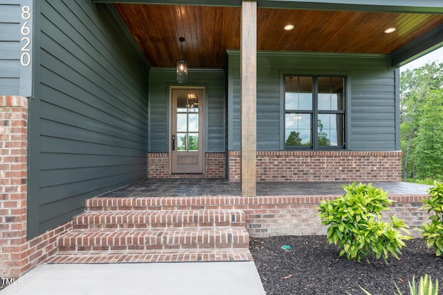 8620 Dukes Lake Rd, Zebulon, NC 27597 - doorway to property featuring covered porch and brick siding