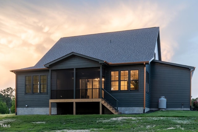 8620 Dukes Lake Rd, Zebulon, NC 27597 - rear view of house with a sunroom, a lawn, roof with shingles, and stairs