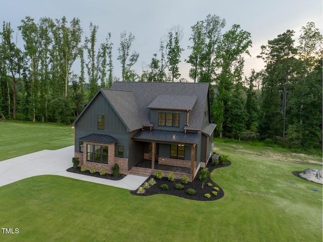 8620 Dukes Lake Rd, Zebulon, NC 27597 - modern inspired farmhouse featuring board and batten siding, a standing seam roof, a lawn, a porch, and driveway