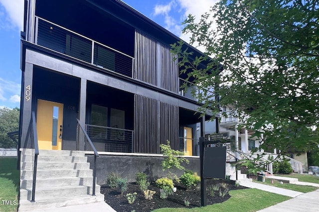 409 Alston St Unit 101, Raleigh, NC 27601 - view of front of home featuring board and batten siding, a porch, and stairway