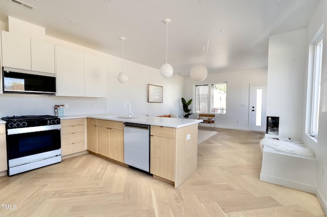 kitchen with a peninsula, visible vents, dishwasher, gas stove, and light brown cabinets