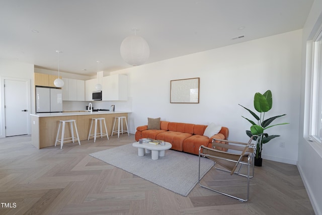 living room featuring baseboards and visible vents